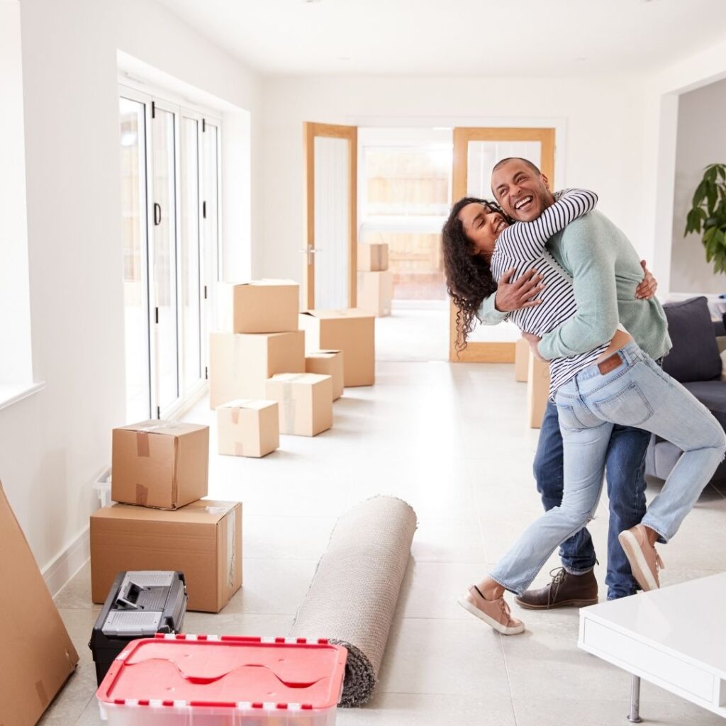 Couples hugging lovingly and moving boxes